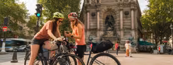 Deux cyclistes consultent leur itinéraire sur smartphone place Saint-Michel à Paris, point de départ de la Véloscénie vers Mont-Saint-Michel.