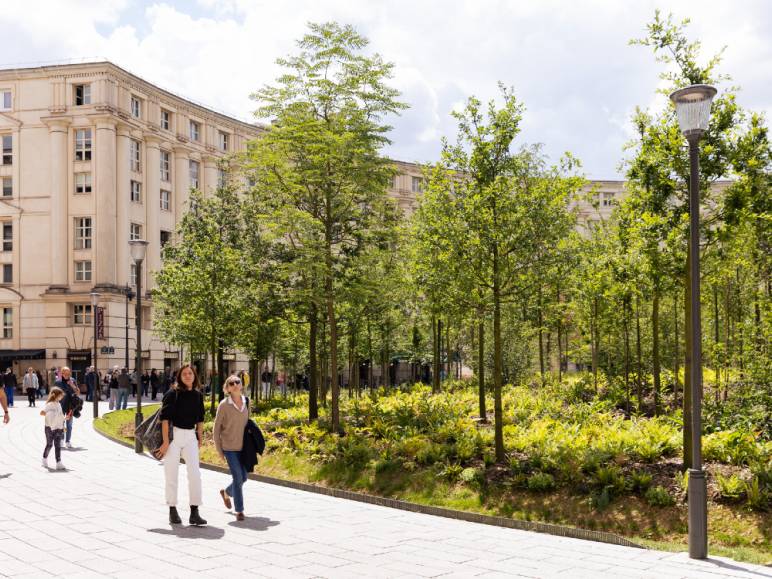 Personnes marchant sur la place de Catalogne et la forêt urbaine à Paris